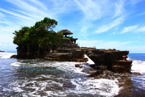 Pemandangan indah salah satu destinasi wisata terbaik di Bali dengan latar laut biru dan pegunungan hijau