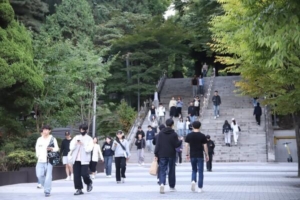 Mahasiswa berjalan di kawasan kampus Korea Selatan dengan latar gedung universitas modern sebagai ilustrasi biaya hidup mahasiswa di Korea Selatan tahun 2027.