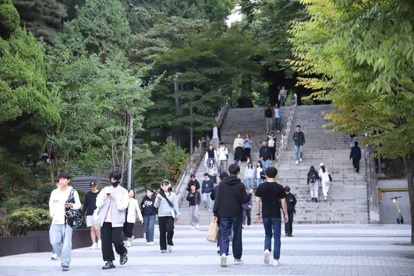 Mahasiswa berjalan di kawasan kampus Korea Selatan dengan latar gedung universitas modern sebagai ilustrasi biaya hidup mahasiswa di Korea Selatan tahun 2027.