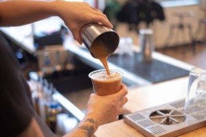 Barista sedang menyiapkan minuman kekinian di sebuah kedai sebagai ilustrasi peluang bisnis minuman di Indonesia.