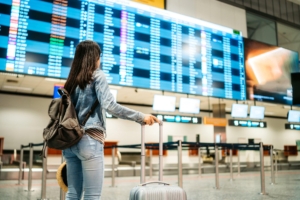 Wisatawan sedang memeriksa tiket pesawat melalui smartphone di bandara sebelum keberangkatan.