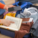 Wisatawan memeriksa checklist persiapan liburan dengan koper dan perlengkapan perjalanan sebelum berangkat.