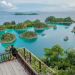 Panorama gugusan pulau karst Raja Ampat di Papua dengan laut biru jernih.