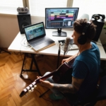 Musisi independen sedang merekam lagu di studio rumahan sebagai ilustrasi strategi promosi musik tanpa label rekaman.
